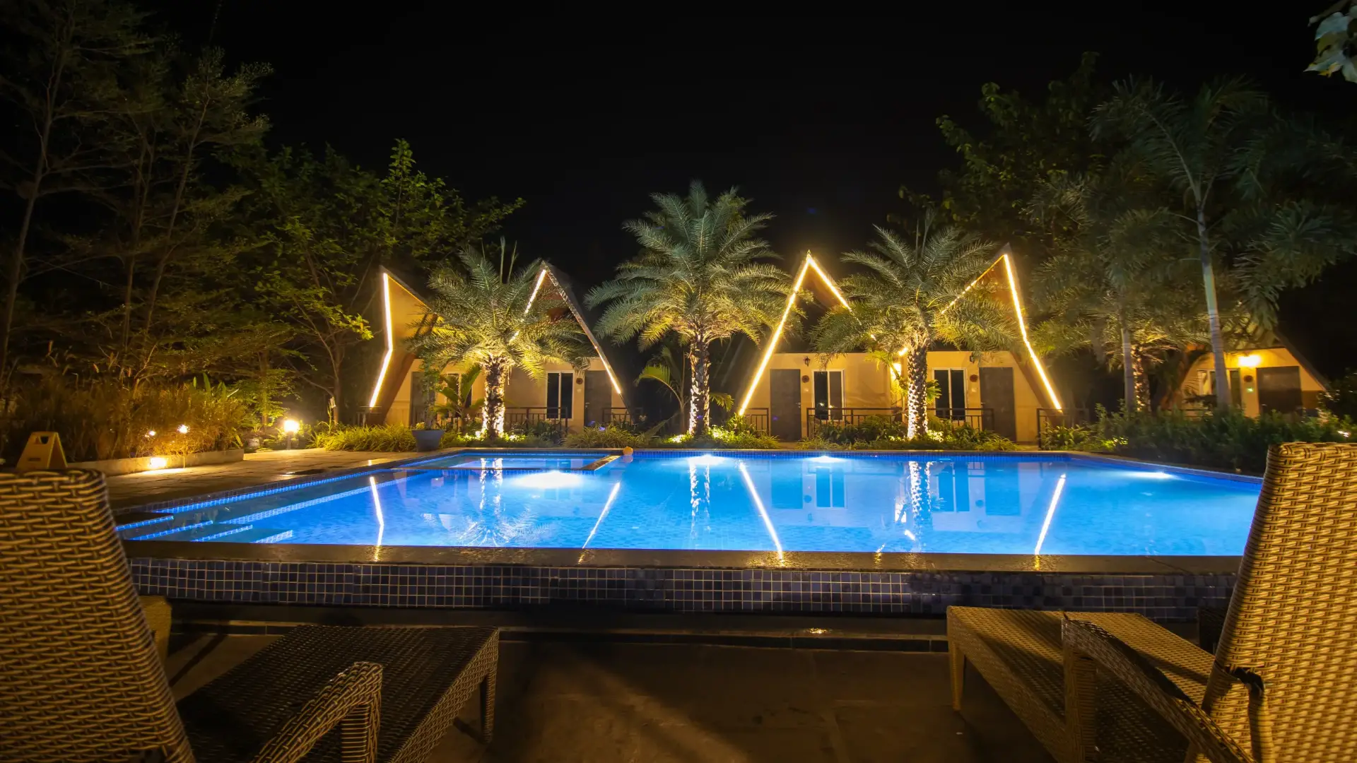 Swimming pool lit up at night at Birds Nest Resort